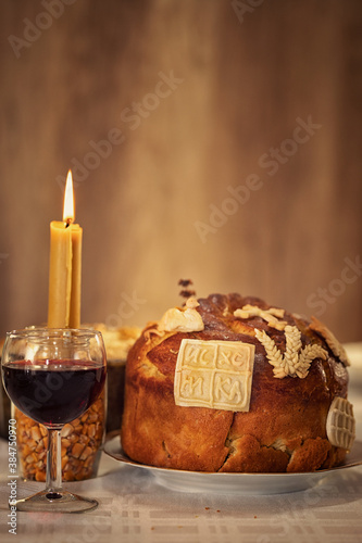 Slava cake decorated with intricate frosting designs that resemble delicate flowers with candle flickers softly, casting warm light and creating a cozy, inviting atmosphere, perfect for celebrating