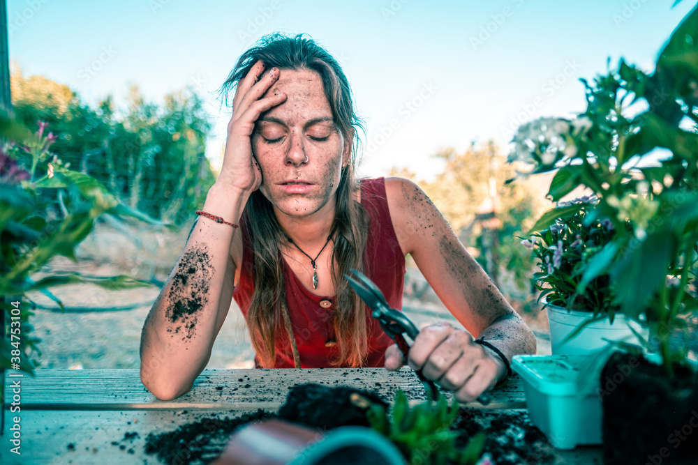 Disappointed caucasian young woman transplanting plants and flowers