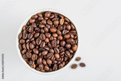 Fototapeta Naklejka Na Ścianę i Meble -  roasted coffee beans in white cup on white background