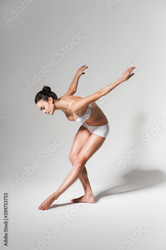 bending healthy woman in white underwear