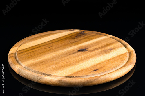wooden round Board for serving on an empty black background