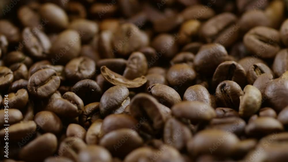 Close up of roasted coffee beans falling down into canvas bag spinning before camera Close up of roasted coffee beans falling down into canvas bag spinning before camera