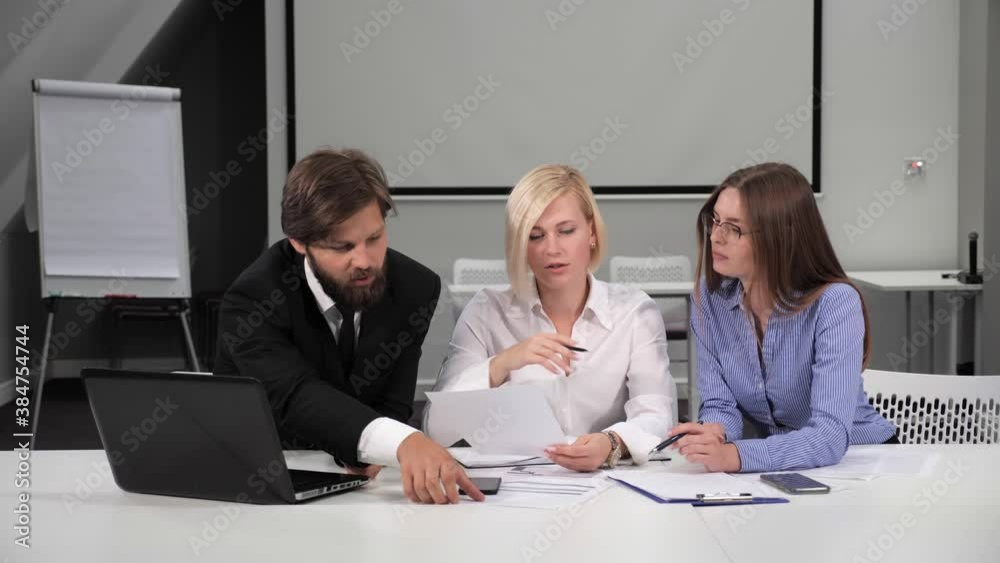 Business meeting in the conference hall of three employees. Businessman in suit talking to business people colleagues or partners sitting at conference table. Business meeting in the conference hall of three employees. Businessman in suit talking to business people colleagues or partners sitting at conference table.