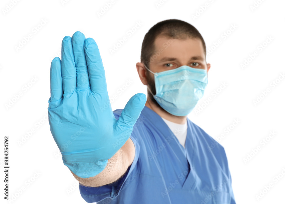 Doctor in protective mask showing stop gesture on white background. Prevent spreading of coronavirus Doctor in protective mask showing stop gesture on white background. Prevent spreading of coronavirus