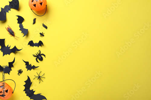 Halloween decor elements on yellow background, flat lay. Space for text