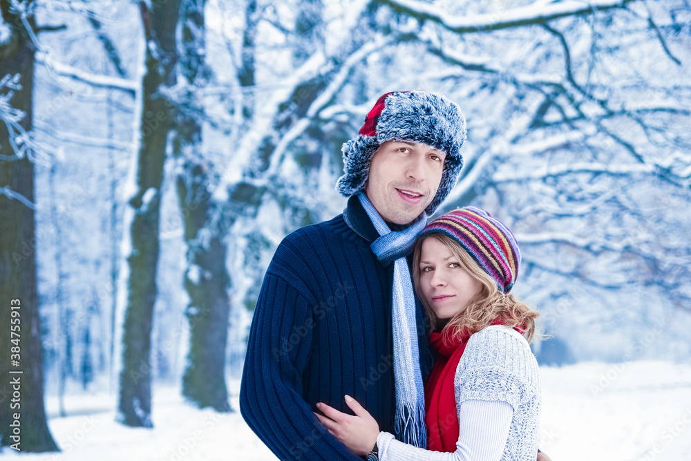 Stylish beautiful couple in winter park on a nature background