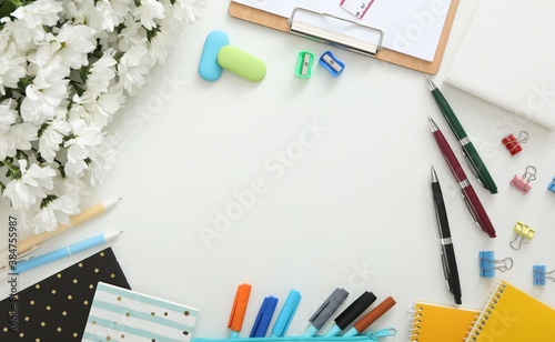 Frame made of flowers and stationery on white background, flat lay with space for text. Teacher's Day