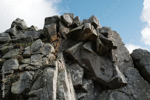 The rugged rocks of Garn Fechan, part of an ancient iron age fort, set against a blue sky with white clouds