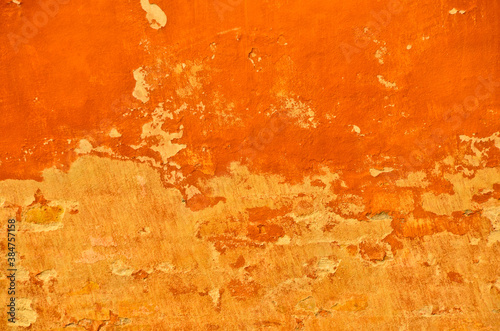 Fotografie bright and vibrant orange coloured finery, plastering part of a wall, old and vi