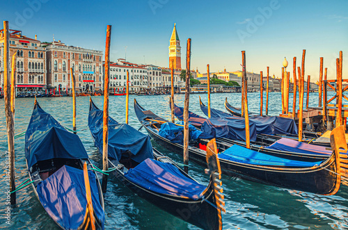 Gondolas moored in water of Grand Canal waterway in Venice. Baroque style colorful buildings along Canal Grande and bell tower Campanile di San Marco. Typical Venice cityscape, Veneto Region, Italy © Aliaksandr