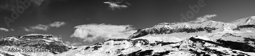 Large panorama of high snowy mountains and sky with clouds