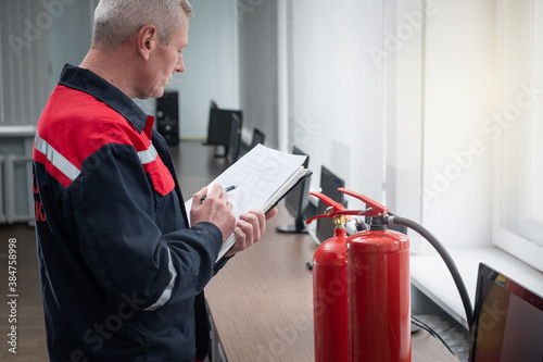 Engineer Professional are Checking A Fire Extinguisher Using Clipboard or checking Industrial fire control system,Fire Alarm controller, Fire notifier, Anti fire.System ready In the event of a fire.