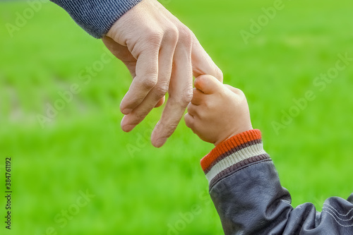 A beautiful hands of parent and child outdoors in the park