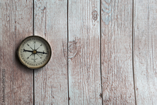 Old compass on a wooden background. Copy space.