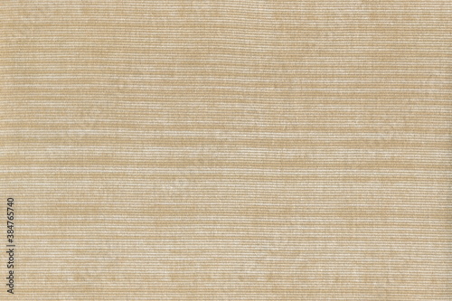 Beige corduroy texture with light stripes. Natural cotton, corduroy. Abstract background of coarse fabric.