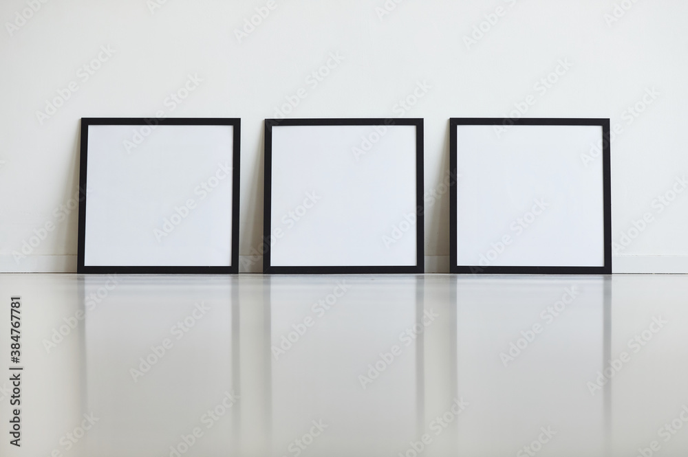 Background image of three identical black frames set against white wall in row at art gallery, copy space Background image of three identical black frames set against white wall in row at art gallery, copy space
