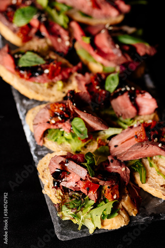 Close-up tasty bruschetta on black table