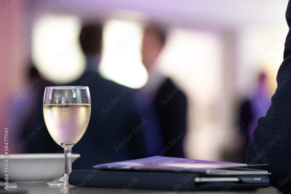 A Glass of White Wine at a Business Reception With People In The Background A Glass of White Wine at a Business Reception With People In The Background