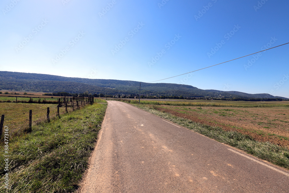 View of a french rural country road at summer on a sunny and warm day.