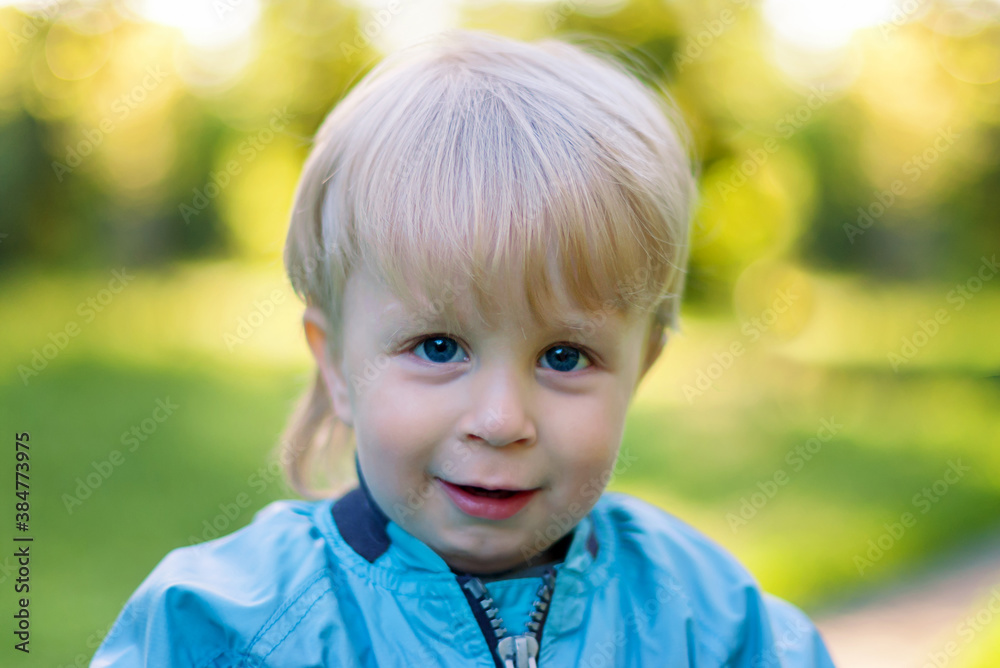 portrait of a little blond boy with blue eyes smiling and looking straight portrait of a little blond boy with blue eyes smiling and looking straight