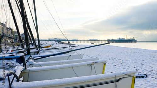 sail boats on a pebble beach on a frozen snowy frosty morning