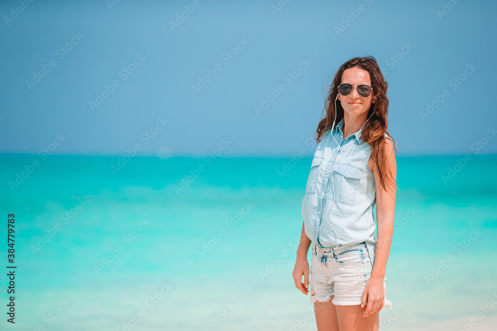 Young beautiful woman having fun on tropical seashore. Happy girl background the blue sky and turquoise water in the sea on caribbean island Young beautiful woman having fun on tropical seashore. Happy girl background the blue sky and turquoise water in the sea on caribbean island