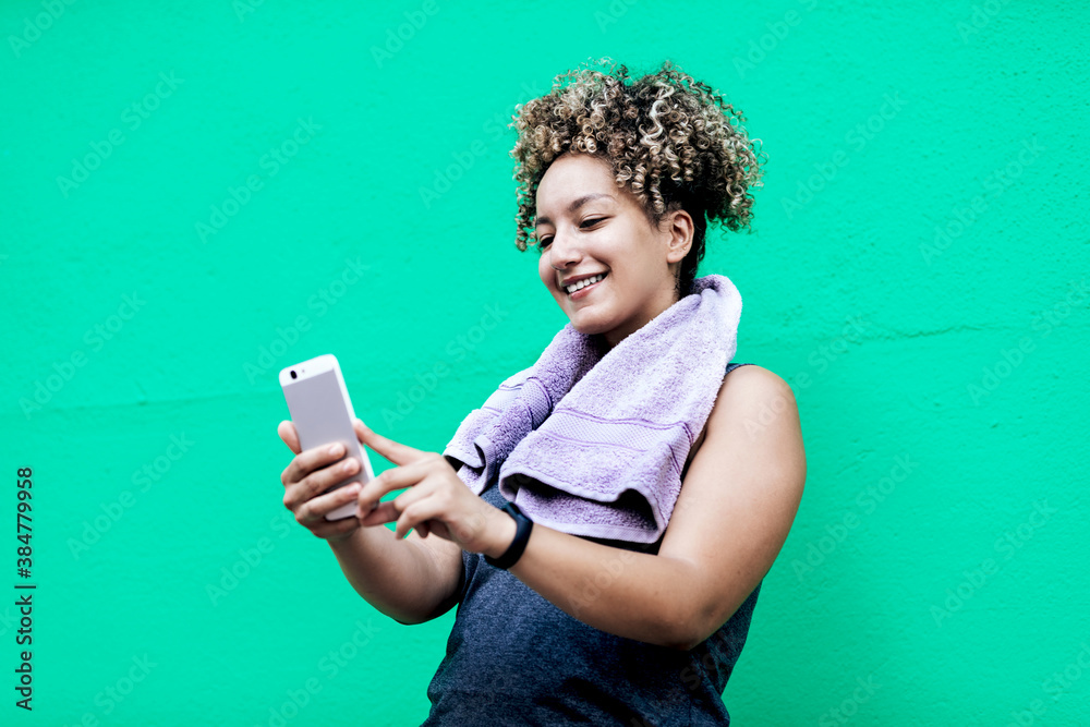 curly-haired woman and sportswear on a green wall curly-haired woman and sportswear on a green wall