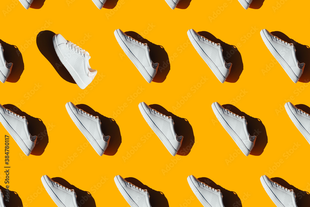 A pattern of white sneakers on an orange background. A pattern of white sneakers on an orange background.