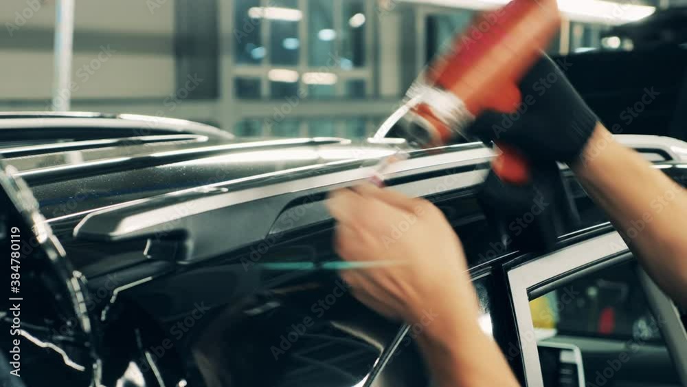 Car manufacturing worker assembling a car roof. Close up Car manufacturing worker assembling a car roof. Close up