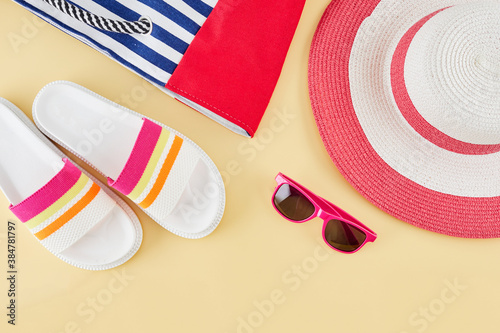 Summer background with straw beach hat, sunglasses, bag and flip flops. Summer travel concept.