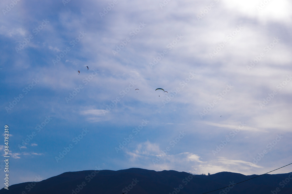 Paragliding. A man flies on a parachute against the blue sky. Paragliding. A man flies on a parachute against the blue sky.