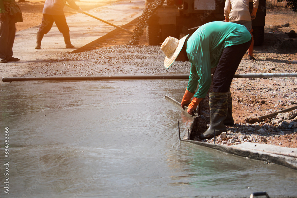 Workers pouring concrete with a cement mixer truck Workers pouring concrete with a cement mixer truck