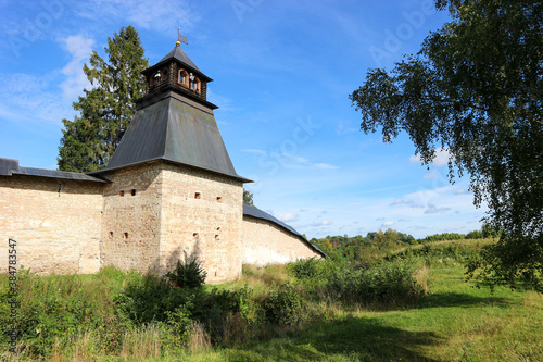 Fortress wall and tower of Pskov-Pechory Dormition Monastery in Pechory, Pskov region, Russia under blue sky