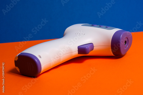 Isometric Medical Digital Non-Contact Infrared Thermometer. It measures the ambient and body temperature without contact and with colored warning symbols.