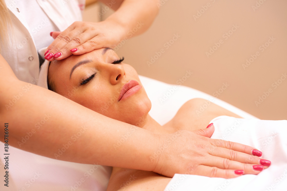 Fototapeta premium Masseuse massaging her clients face