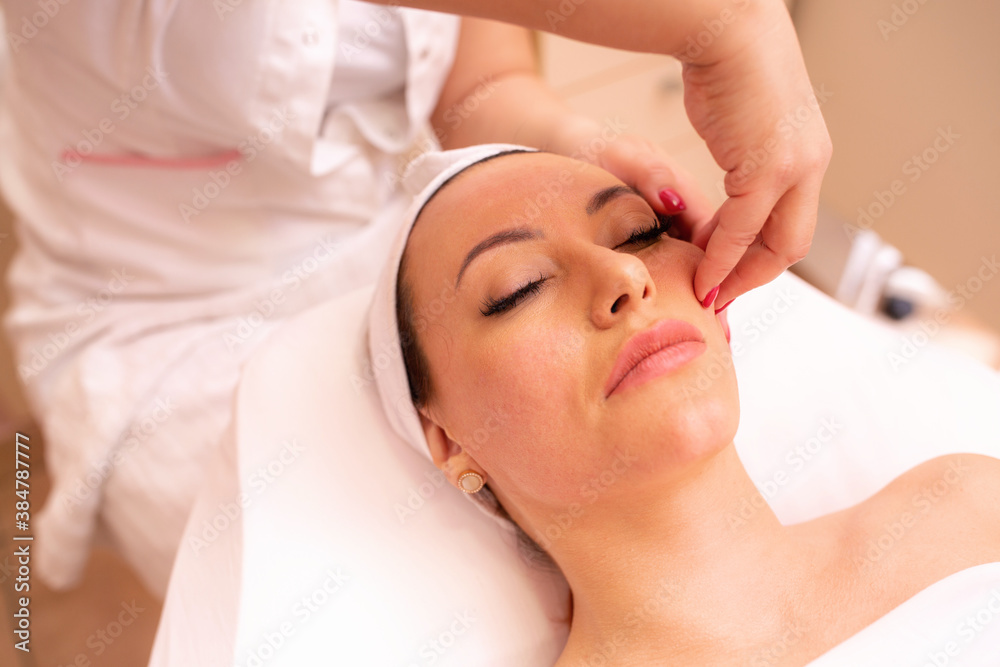 Woman undergoing a facial madero massage in spa center Woman undergoing a facial madero massage in spa center