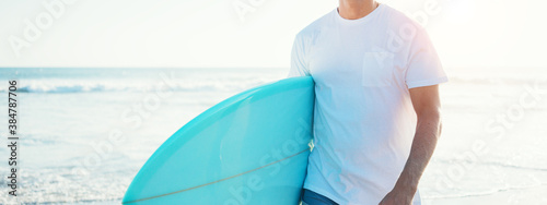 Photography Young guy surfer walking with surfboard near the ocean