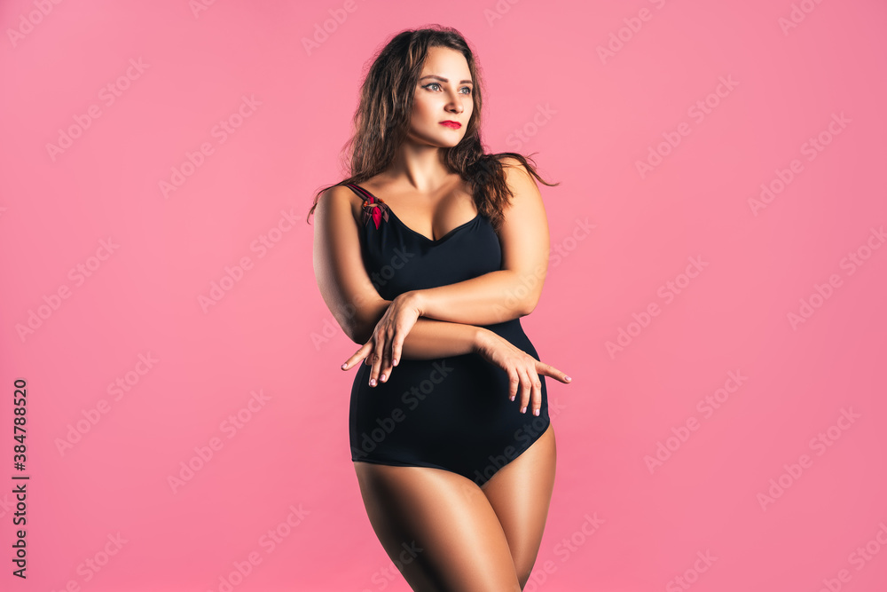 Obraz premium Sexy plus size fashion model in black one-piece swimsuit, fat woman in lingerie on pink background