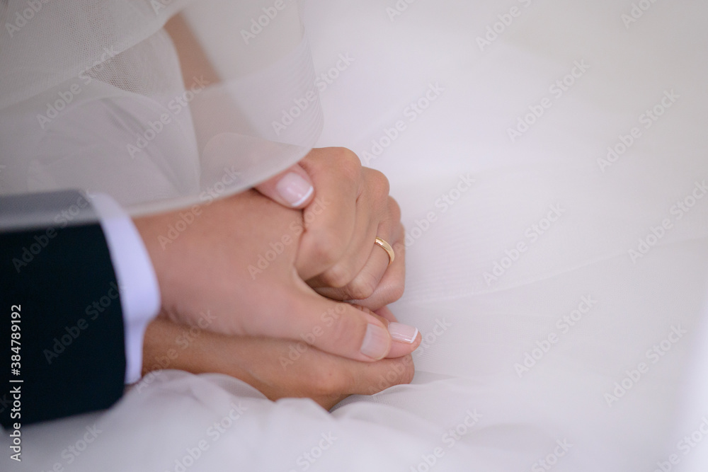 Primo piano di entrambe le mani una sopra l’altra degli sposi durante il rito matrimoniale Primo piano di entrambe le mani una sopra l’altra degli sposi durante il rito matrimoniale