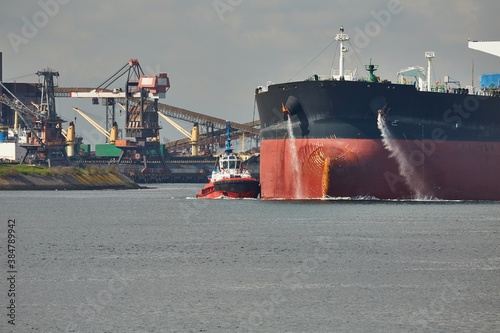 Fototapeta Large crude oil tanker ship pumping out ballast water when coming into port in R
