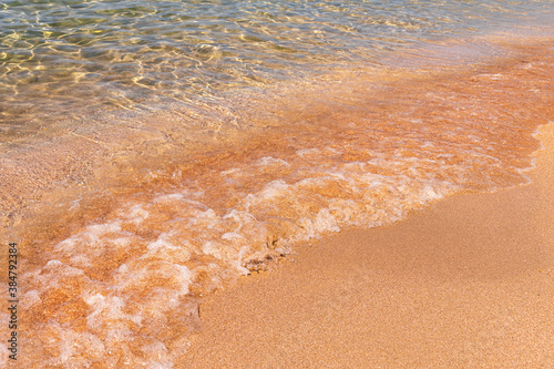 Fototapeta Naklejka Na Ścianę i Meble -  Calm wave of the sea on a golden sandy beach. Seaside holidays and vacations