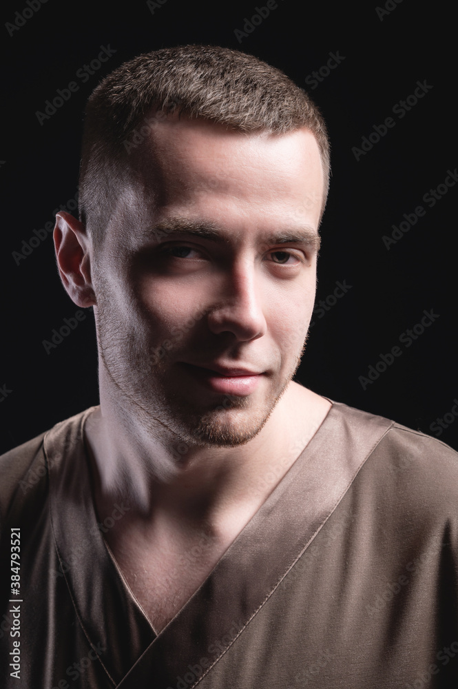 Studio portrait of large young man in casual attire looking at camera arms crossed