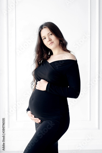 beautiful young pregnant woman in dark black dress