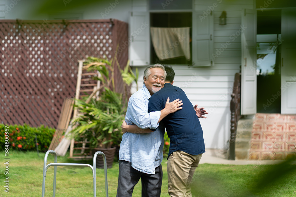Senior Asian Father With Adult grown Son hugging outdoors