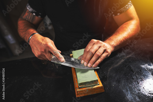 Man's hands sharpening knife