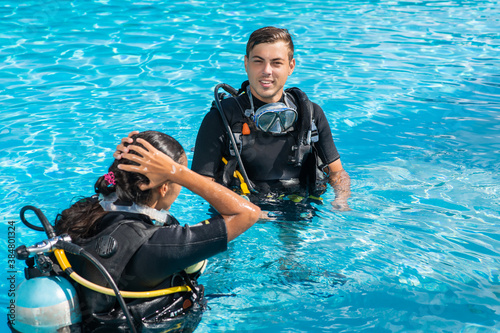 Diving training in the pool. Man and woman in scuba gear and all equipment