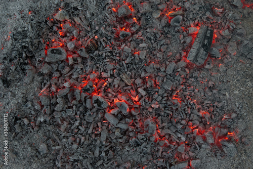 Glowing embers and ash on fireplace after bonfire.