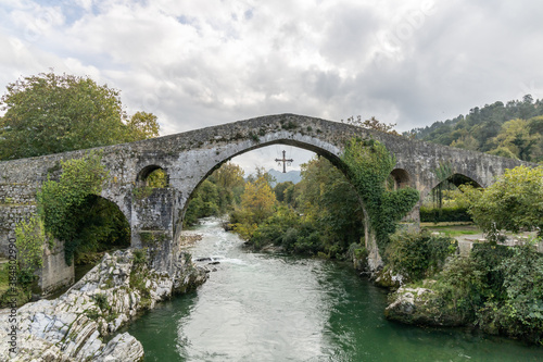 Roman bridge in the city of Cangas de Onis, Spain with the cross of victory hanging from the arch.