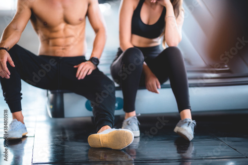 Personal trainer helping woman exercising in the sport gym