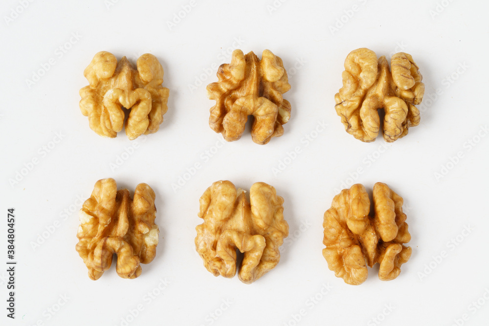 Rows of raw walnut halves on white background Rows of raw walnut halves on white background